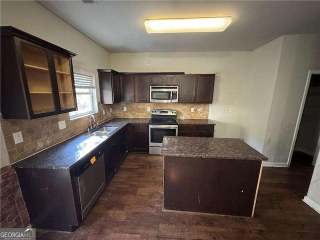 kitchen with dark hardwood / wood-style flooring, dark brown cabinetry, stainless steel appliances, sink, and a kitchen island