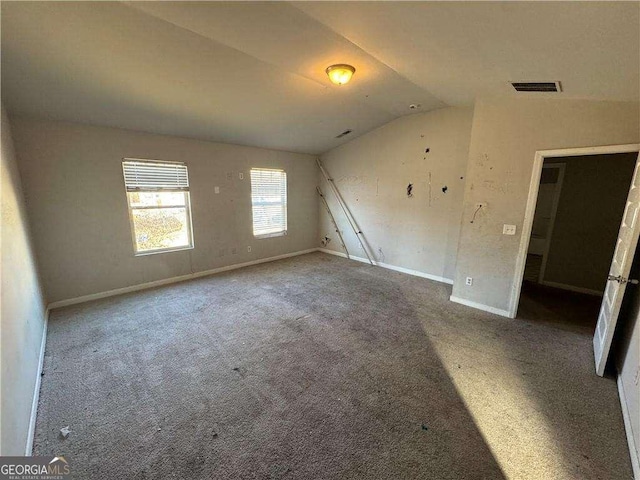 carpeted spare room featuring lofted ceiling