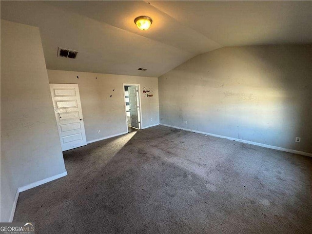 carpeted spare room featuring lofted ceiling