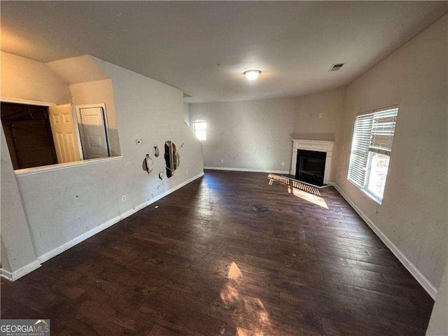 unfurnished living room featuring lofted ceiling and dark wood-type flooring