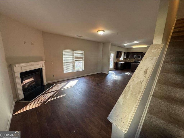 unfurnished living room featuring dark wood-type flooring