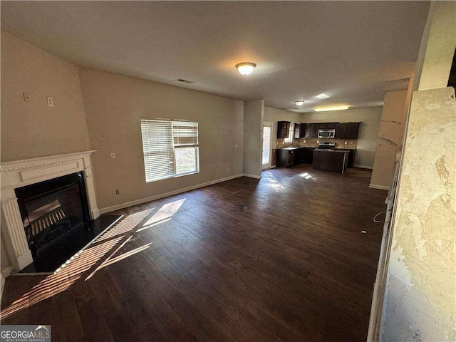 unfurnished living room with dark hardwood / wood-style flooring