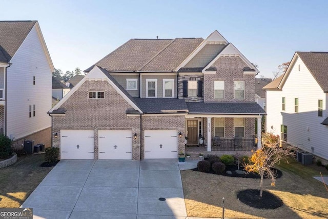 view of front of home with central air condition unit, covered porch, a front yard, and a garage