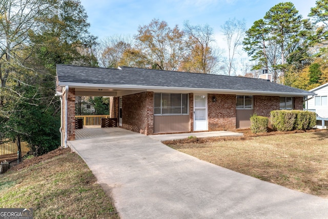 ranch-style home featuring a front lawn and a carport