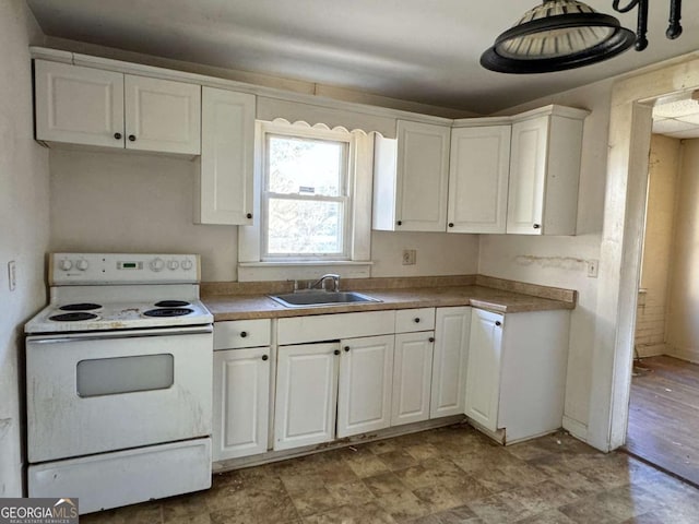 kitchen with electric range, sink, and white cabinets