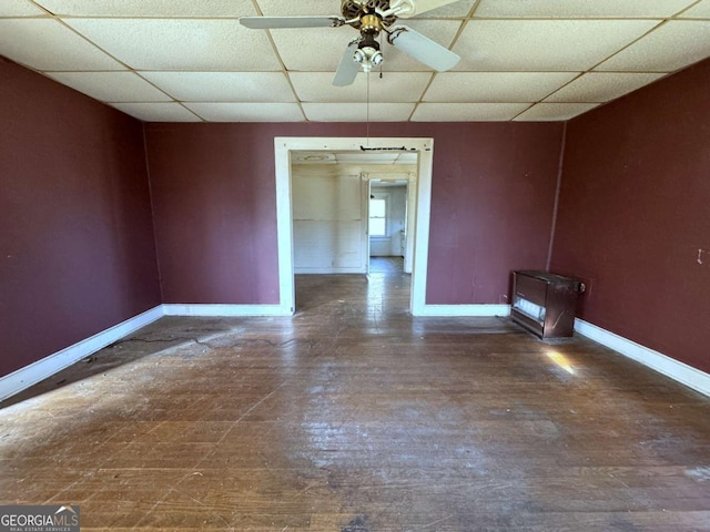 spare room with a paneled ceiling, dark hardwood / wood-style floors, and ceiling fan