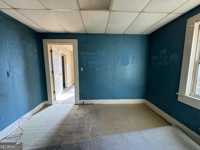 carpeted spare room featuring a paneled ceiling