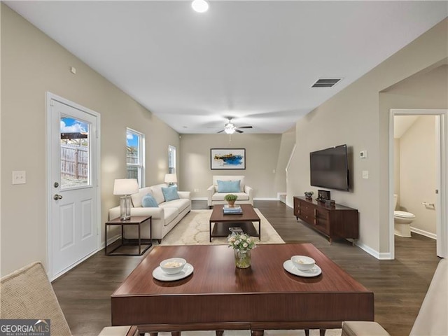 living room featuring ceiling fan and dark hardwood / wood-style flooring