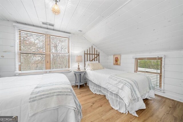 bedroom featuring wooden ceiling, wood-type flooring, wooden walls, and vaulted ceiling