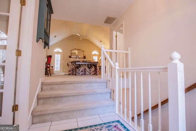 stairs with tile patterned floors, ceiling fan, and vaulted ceiling