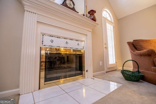 interior details featuring a tiled fireplace and carpet floors