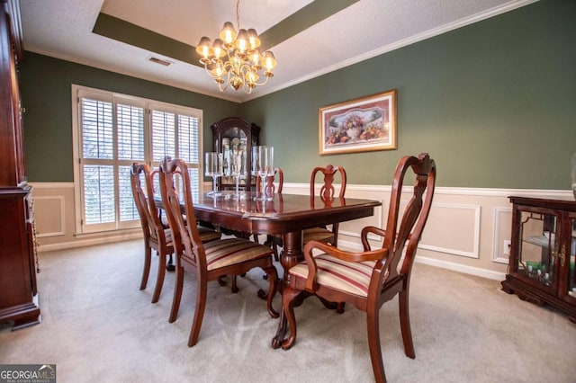 carpeted dining area featuring ornamental molding, a textured ceiling, and a notable chandelier