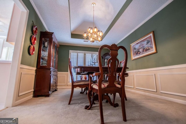 carpeted dining space featuring crown molding and an inviting chandelier