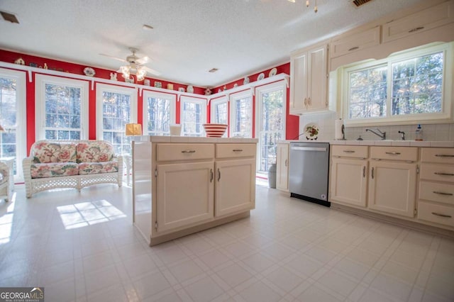 kitchen featuring dishwasher, ceiling fan, sink, and a textured ceiling