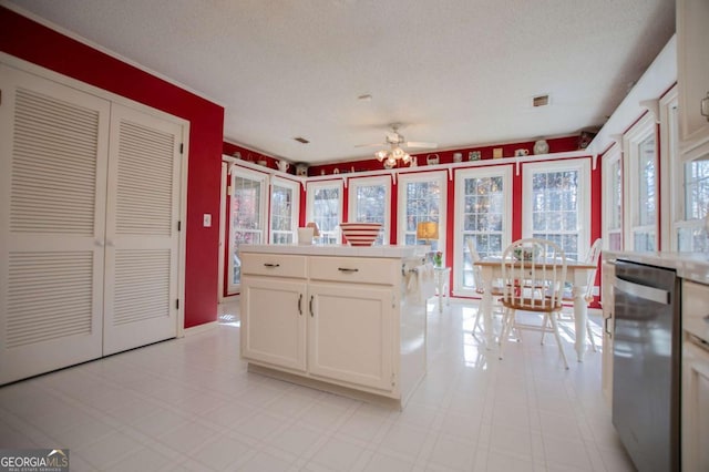 kitchen with dishwasher, ceiling fan, white cabinetry, and a textured ceiling