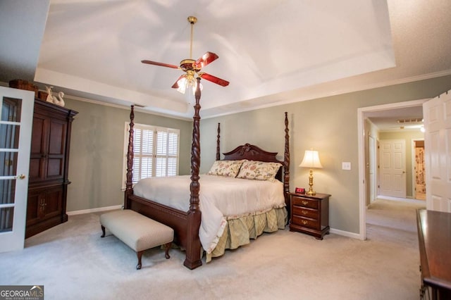 carpeted bedroom featuring a tray ceiling, ceiling fan, and crown molding