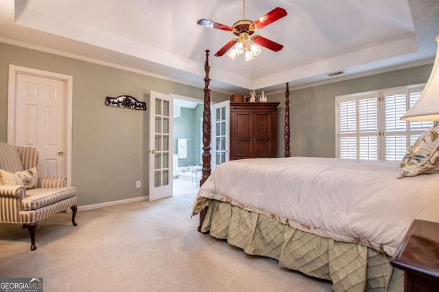 carpeted bedroom with french doors, crown molding, ceiling fan, connected bathroom, and a tray ceiling