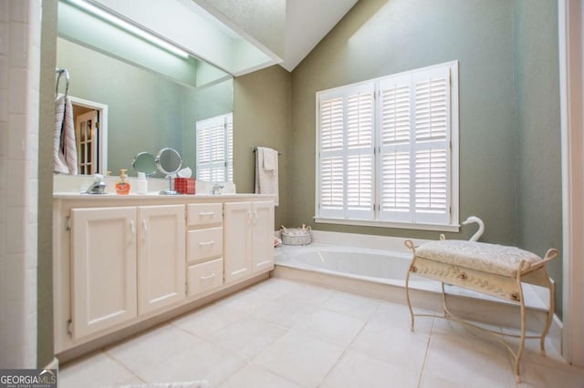 bathroom featuring tile patterned flooring, vanity, vaulted ceiling, and a washtub