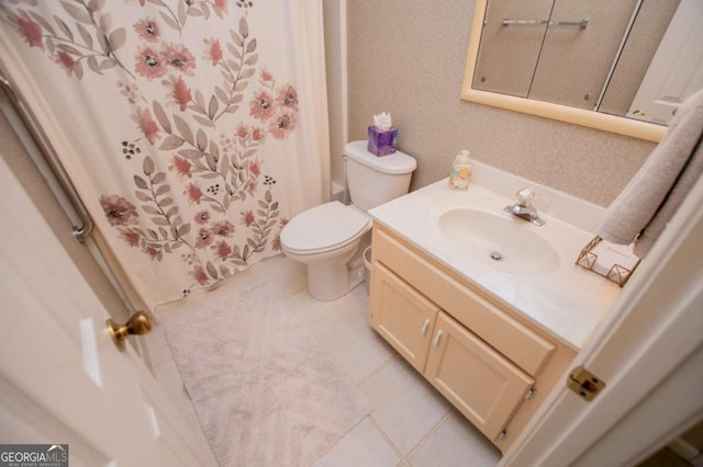 bathroom with tile patterned flooring, vanity, and toilet