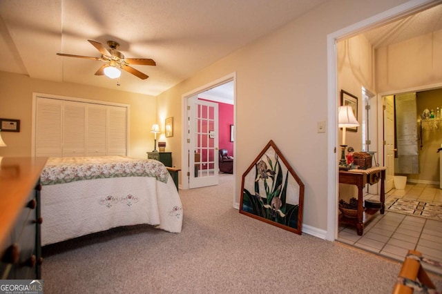 carpeted bedroom featuring ceiling fan, a closet, and ensuite bathroom