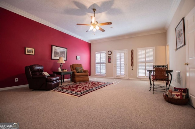 living area featuring ceiling fan, carpet, a textured ceiling, and ornamental molding