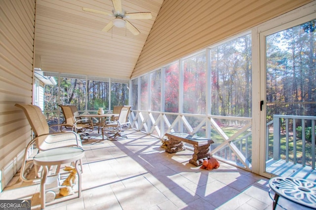 sunroom with ceiling fan and vaulted ceiling