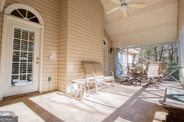 unfurnished sunroom with vaulted ceiling and ceiling fan