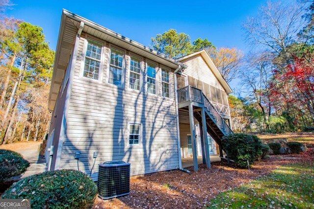 back of property featuring central AC and a sunroom