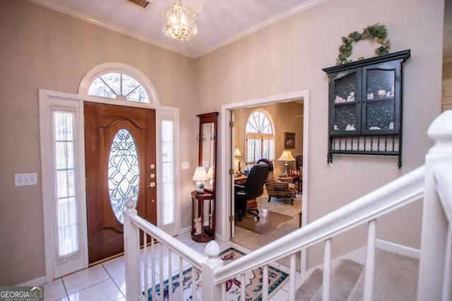 foyer entrance with a chandelier, light tile patterned floors, and ornamental molding