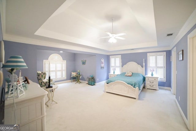 carpeted bedroom with ceiling fan, a raised ceiling, and crown molding