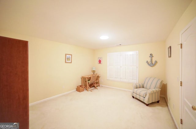 sitting room featuring light colored carpet