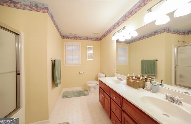 bathroom featuring vanity, toilet, and a shower with shower door