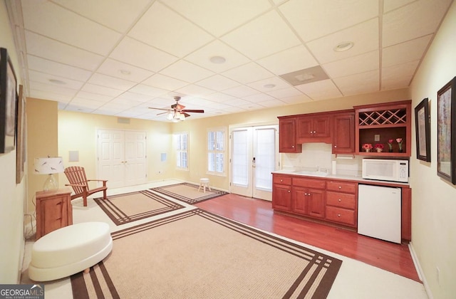 kitchen with ceiling fan, french doors, sink, hardwood / wood-style floors, and white appliances