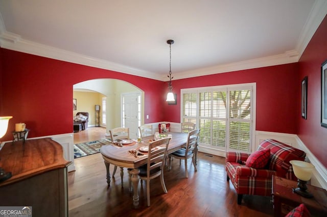 dining area featuring wood-type flooring and crown molding