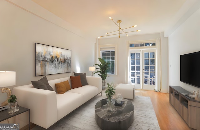 living room with a notable chandelier and light wood-type flooring