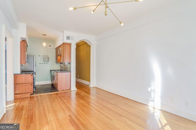 unfurnished living room with sink and light hardwood / wood-style flooring