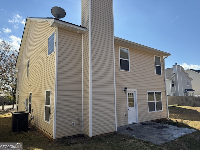 back of property with central AC and a patio area