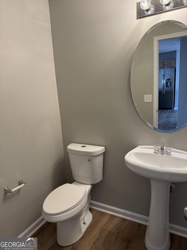 bathroom with wood-type flooring and toilet