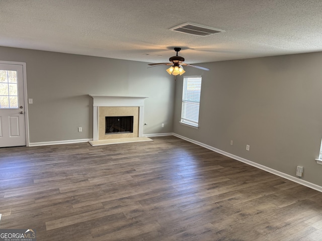 unfurnished living room with ceiling fan, dark hardwood / wood-style floors, and a textured ceiling