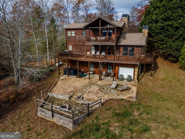 back of house with a balcony, a patio, a deck, a yard, and a garage