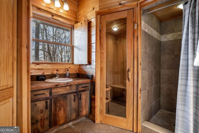 bathroom featuring tile patterned flooring, a shower with curtain, vanity, and wooden walls