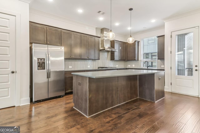 kitchen featuring dark hardwood / wood-style flooring, ornamental molding, dark brown cabinetry, decorative light fixtures, and a kitchen island