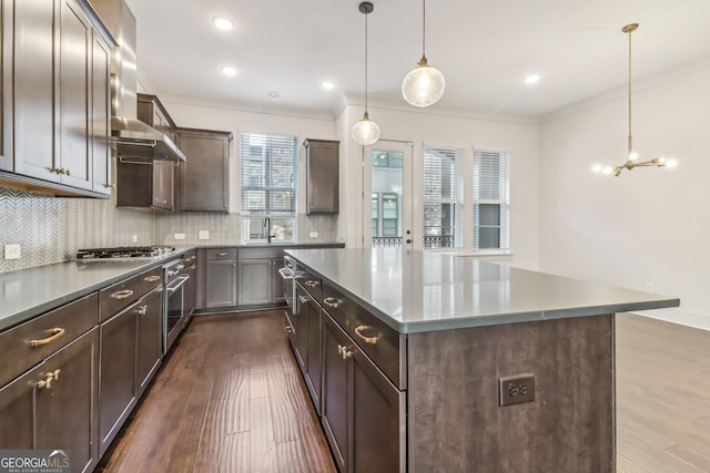 kitchen with oven, decorative light fixtures, ceiling fan, dark hardwood / wood-style floors, and a large island