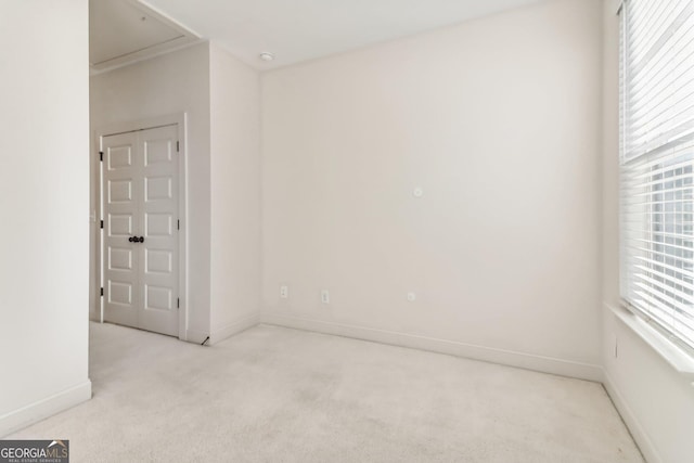 spare room featuring light colored carpet