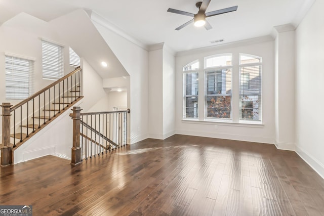 unfurnished living room with a wealth of natural light, ceiling fan, dark hardwood / wood-style floors, and ornamental molding