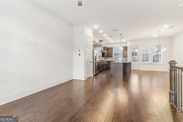 unfurnished dining area with a chandelier, ornamental molding, and dark wood-type flooring