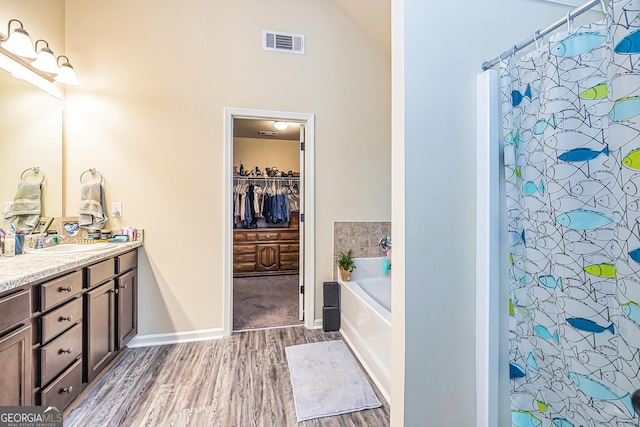 bathroom with vanity, wood-type flooring, and shower with separate bathtub