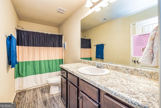 bathroom with hardwood / wood-style floors, vanity, and toilet