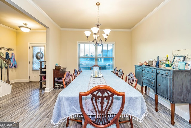 dining room featuring a chandelier, hardwood / wood-style floors, ornamental molding, and a healthy amount of sunlight