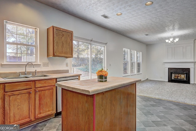 kitchen featuring a wealth of natural light, dishwasher, sink, and a center island